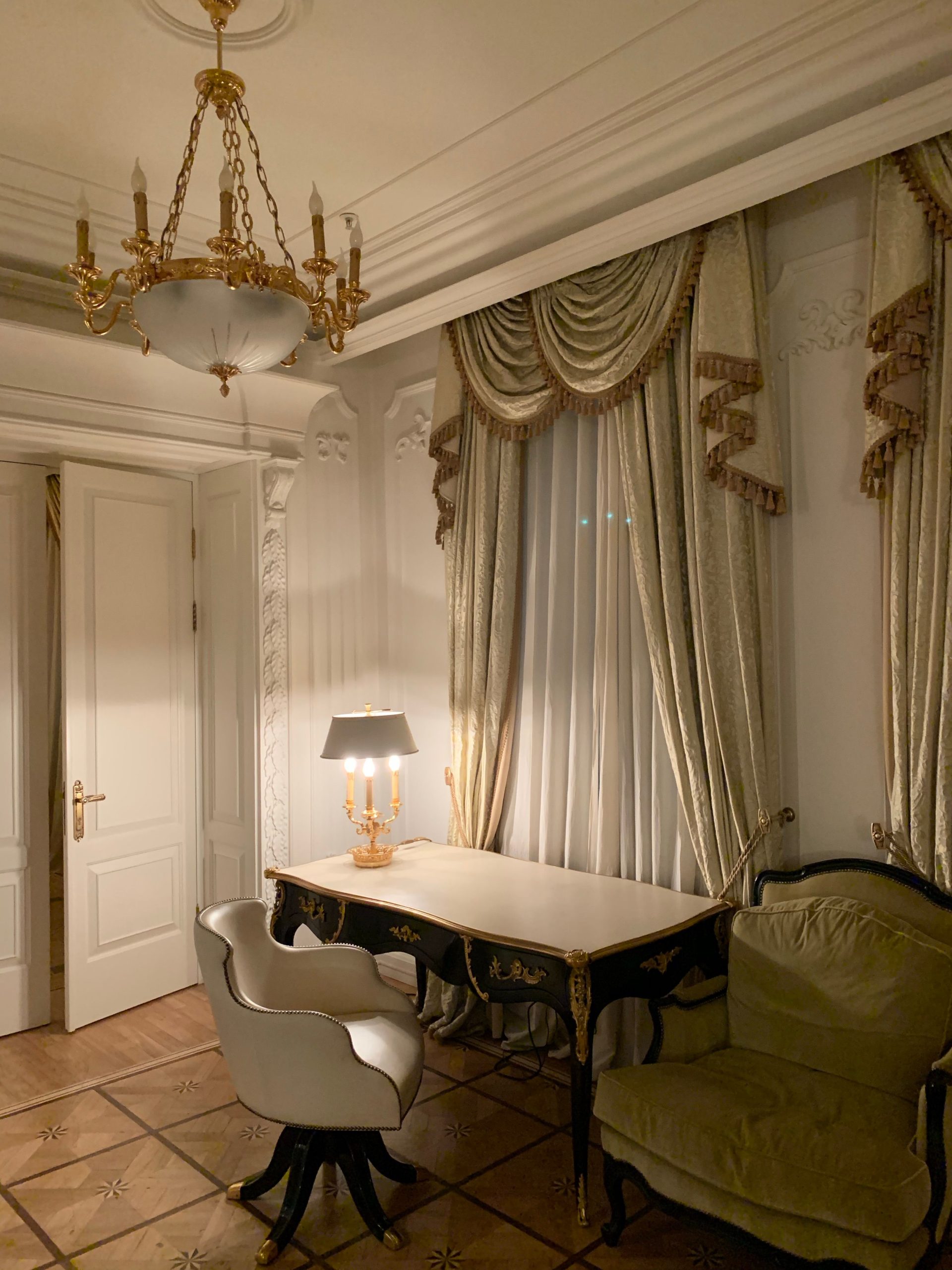 Luxurious hotel suite with chandelier and ornate decor, symbolizing high-end discretion