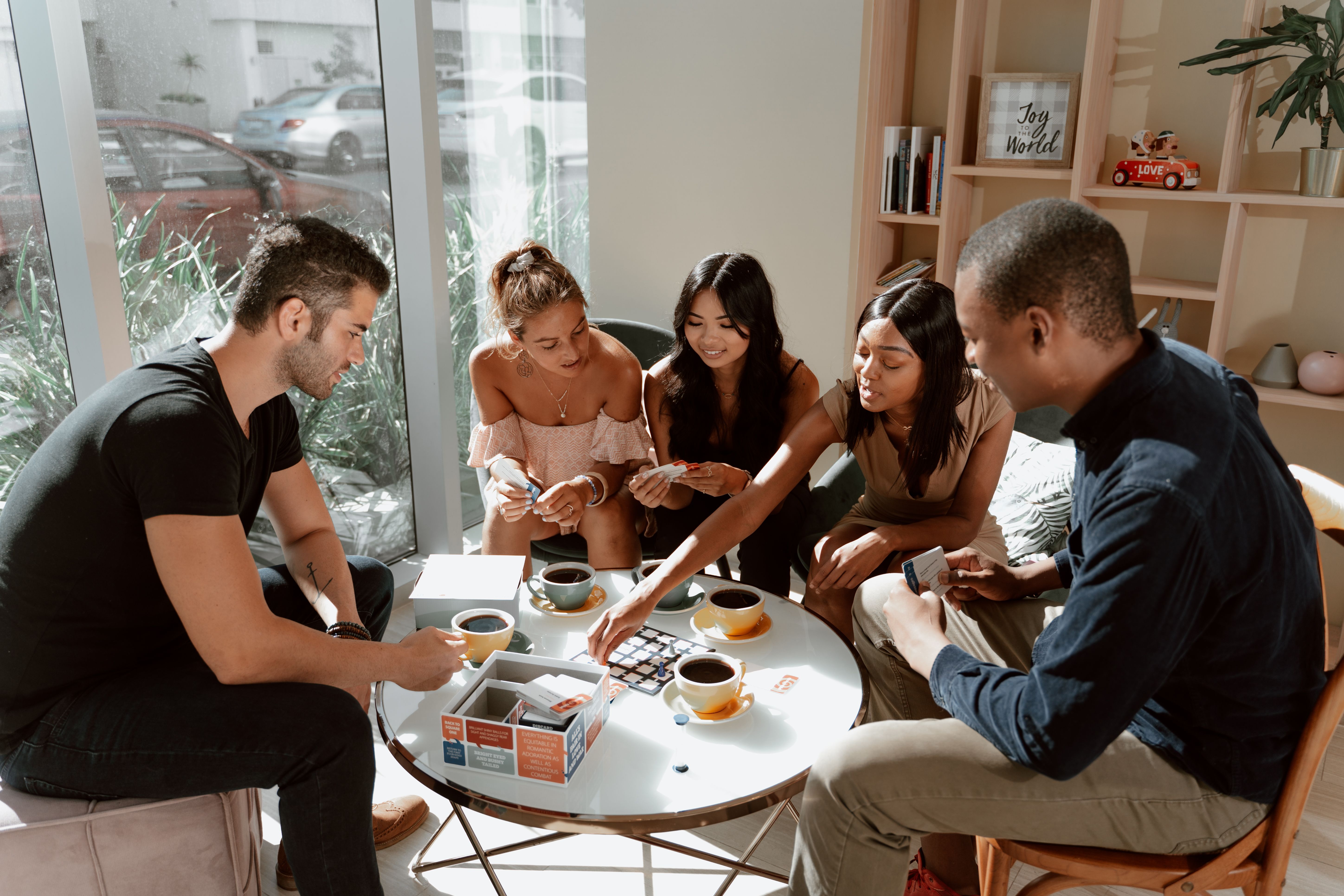 Diverse friends gathered around a table playing a board game together