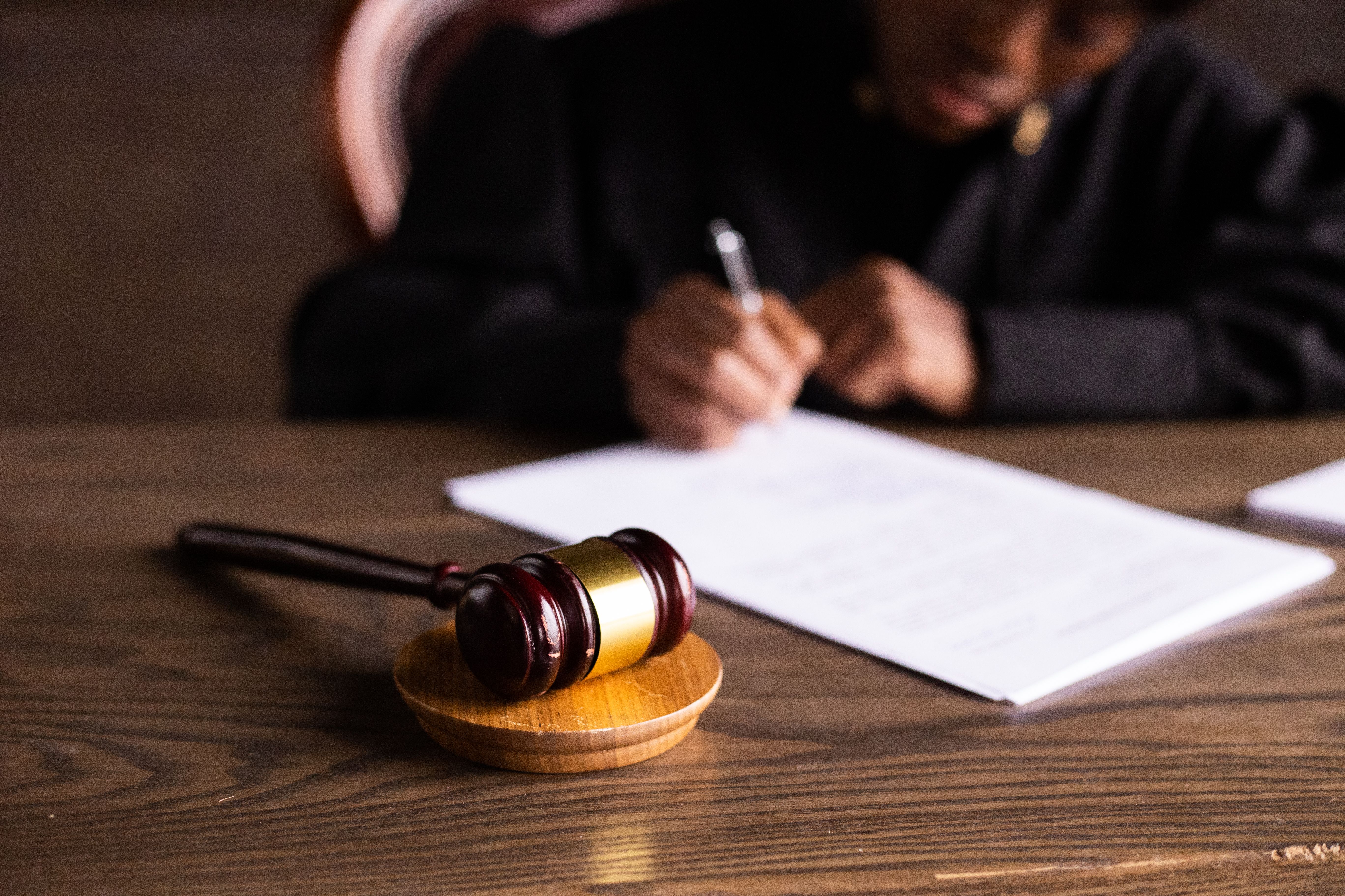 Judge signing documents at a desk with a gavel, symbolizing rulings as a case moves through the court system