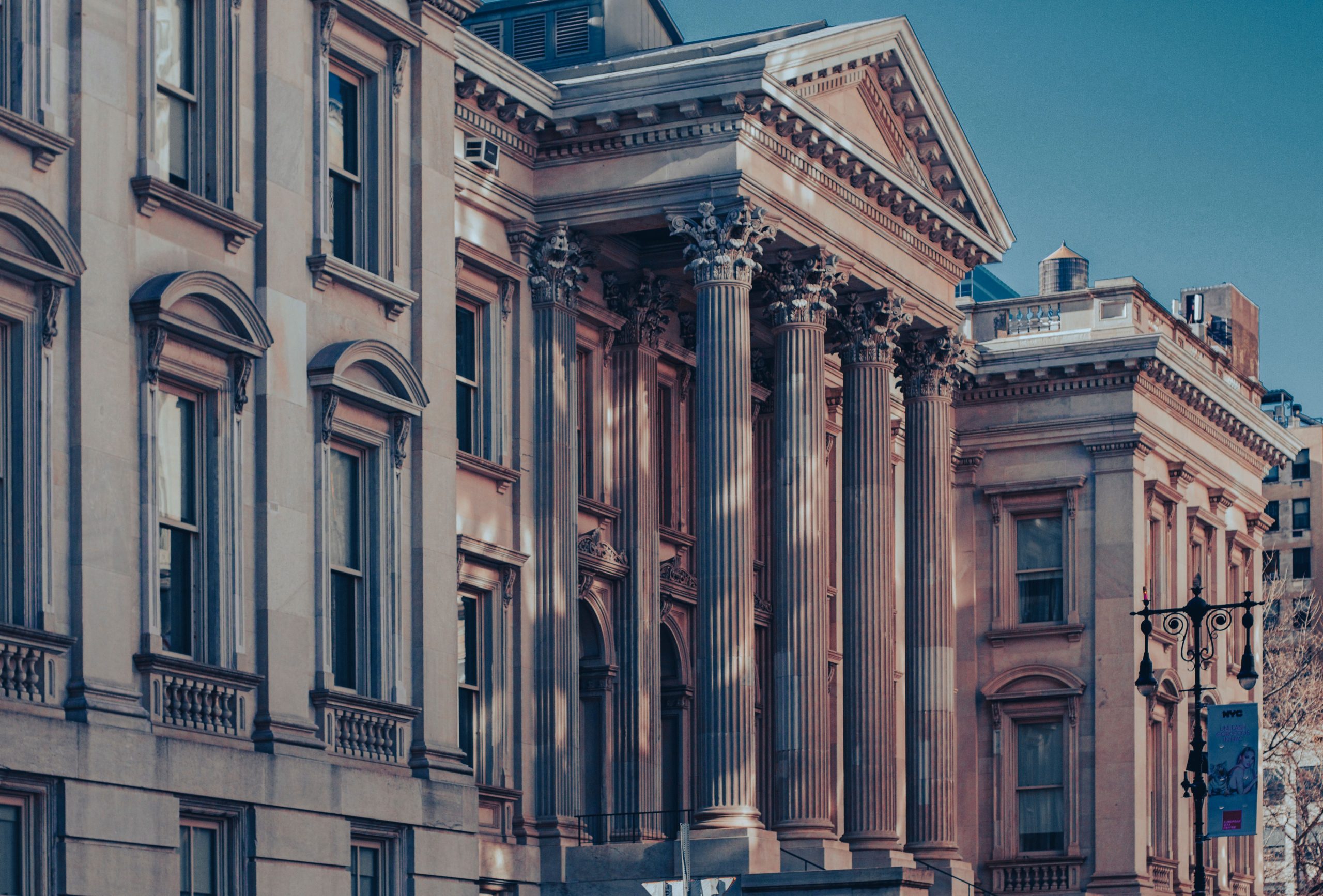 Neoclassical courthouse exterior with tall columns at dusk, representing where large legal cases are heard