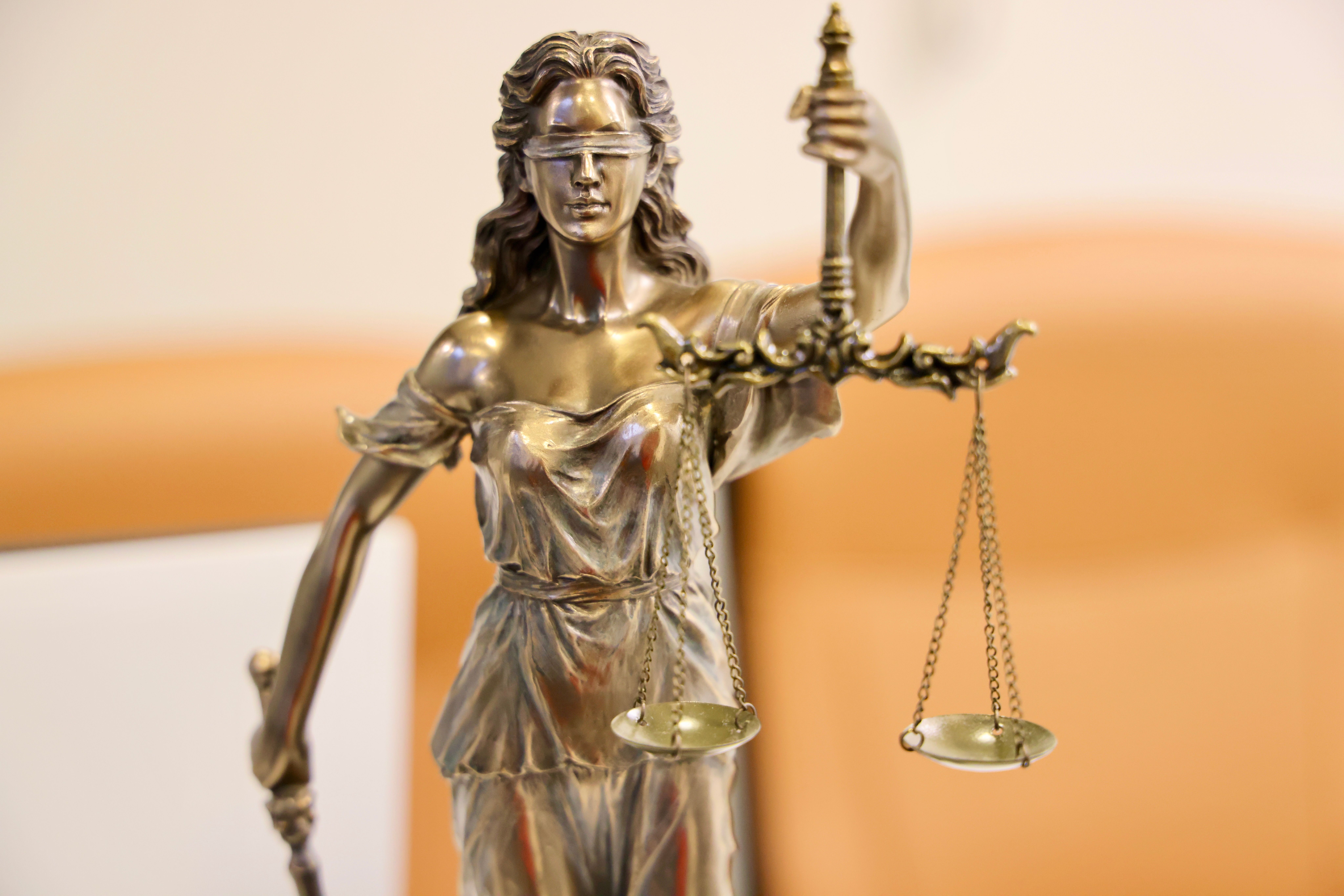 Lady Justice statue holding scales, symbolizing fairness and due process in the court system