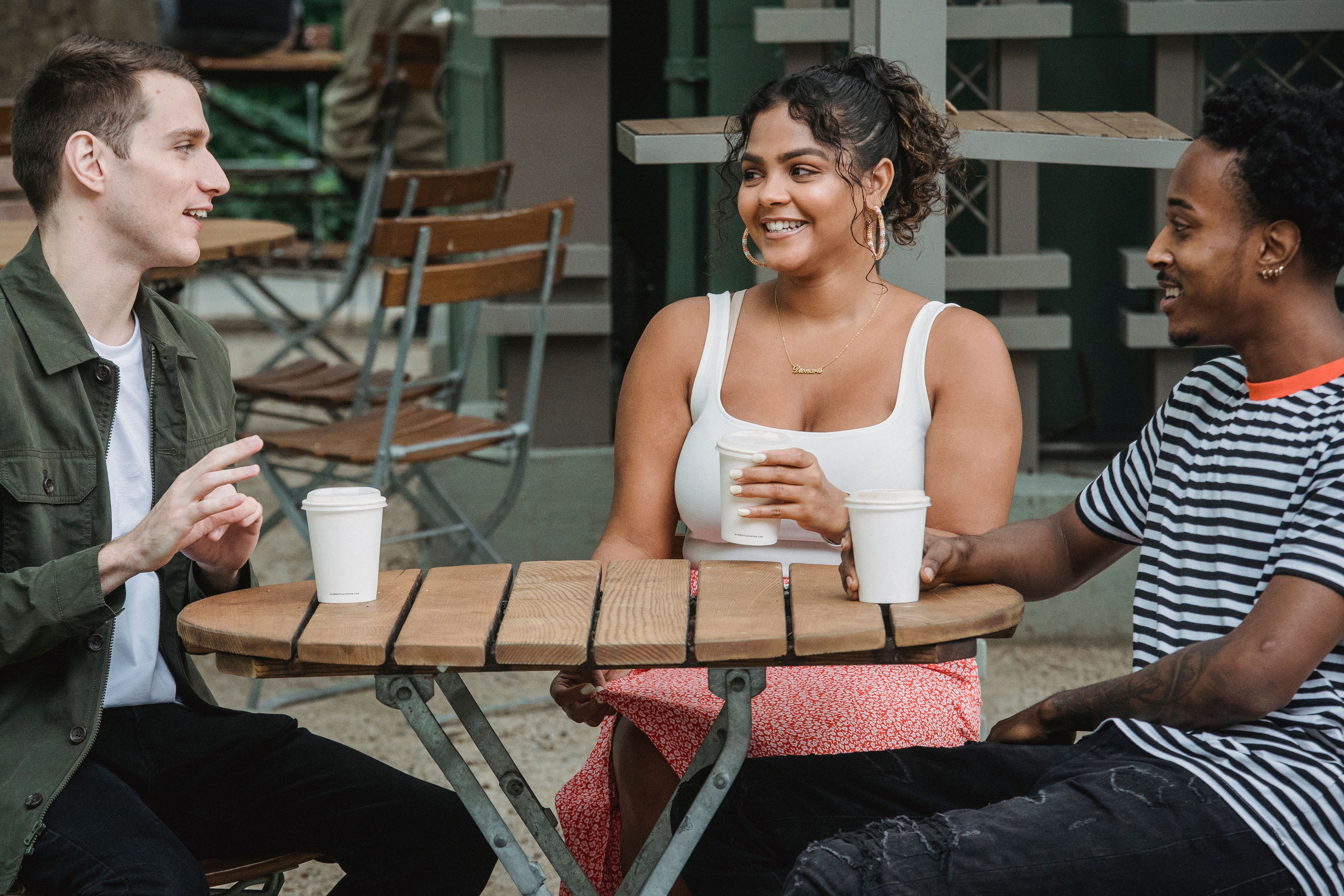 Diverse young friends socializing together at an outdoor cafe